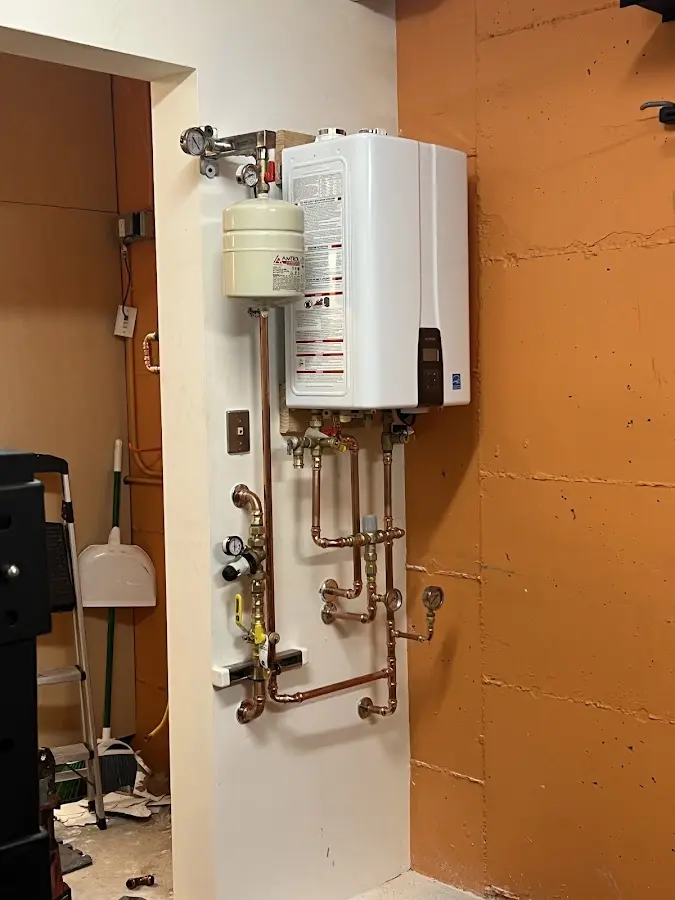 Plumbing technician inspecting water heater connections in Gastonia